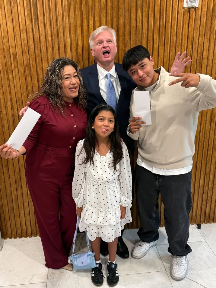 Houston attorney Drew Shirley pulling a funny face with a mother and her two children after their injury case concluded